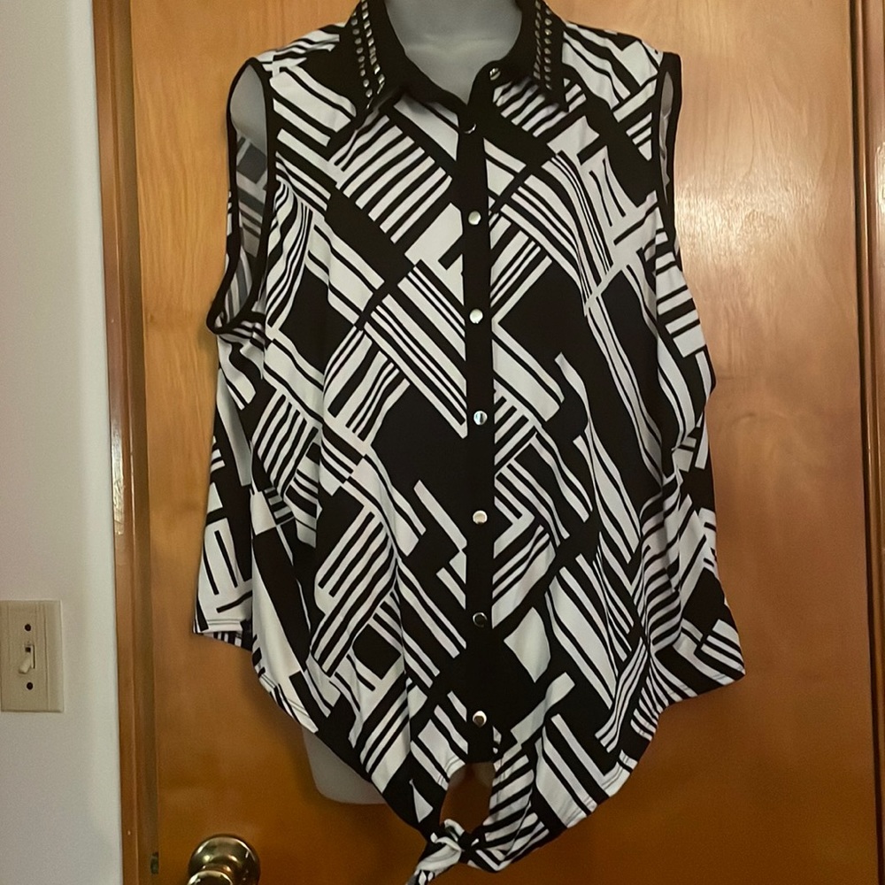 Sleeveless black and white printed blouse. Collar has circle and square rivets.
